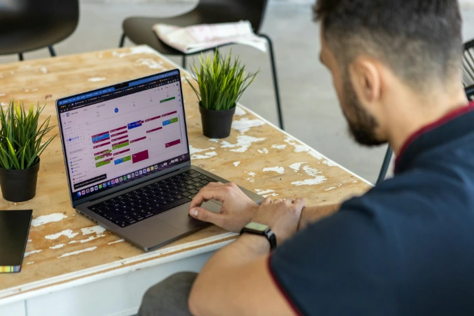 a man sitting at a table using a laptop computer